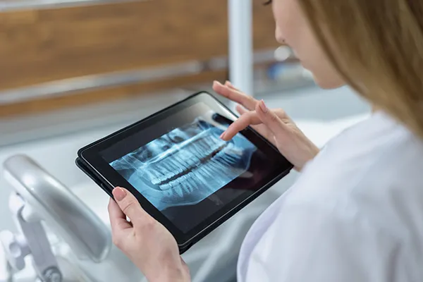 female looking at digital x ray on a tablet device