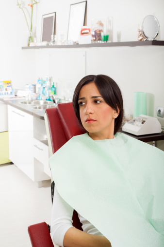 Anxious woman in dental chair benefits from dental sedation by Dr. Djawdan.